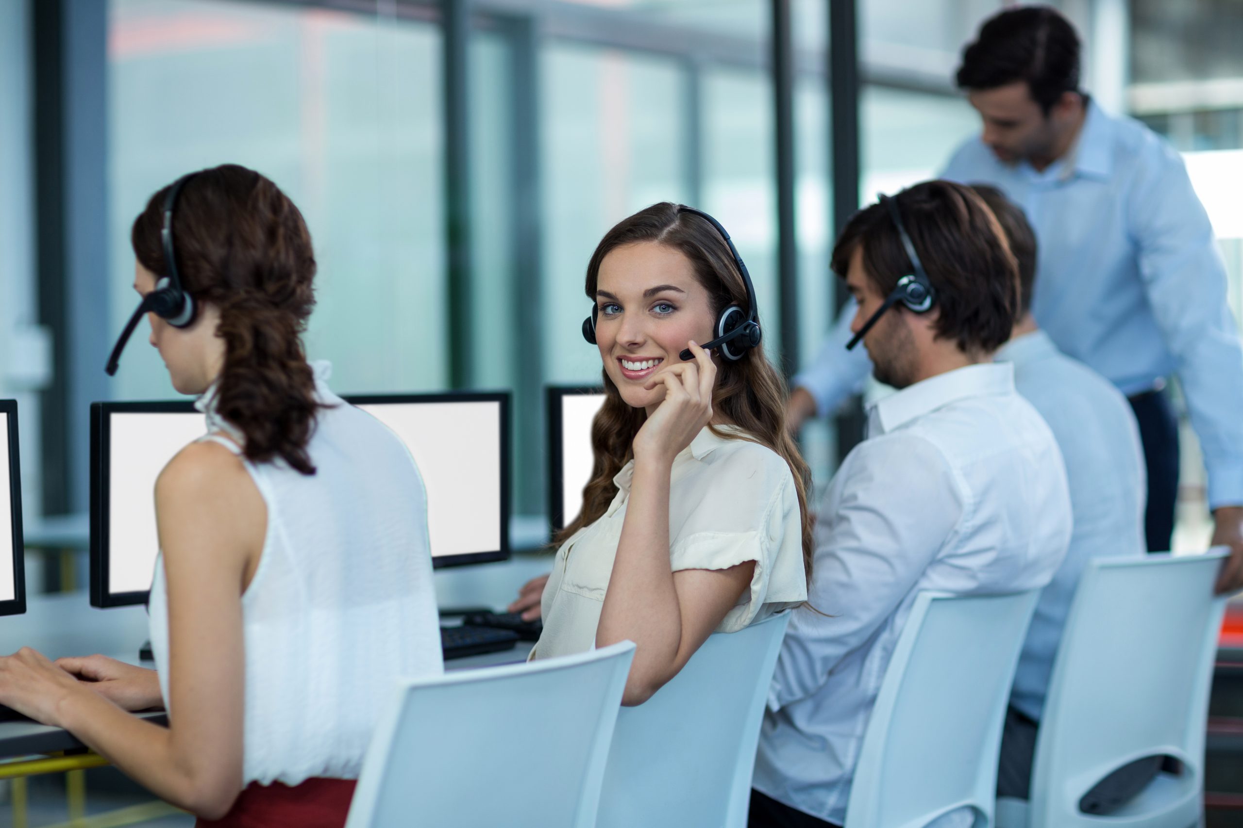 Business executives with headsets using computer in office Image